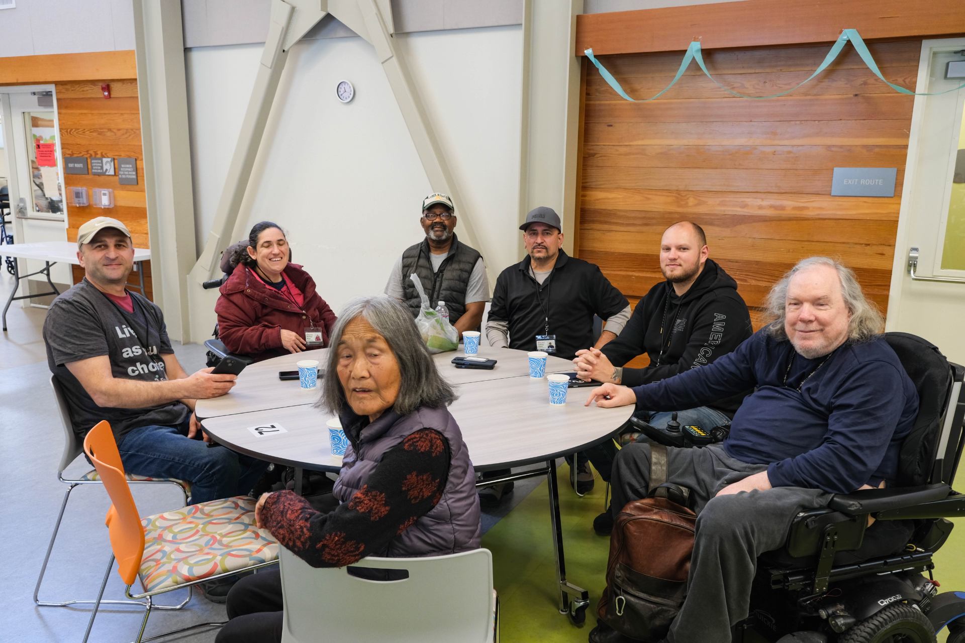 A group of people sitting around a round table Description automatically generated